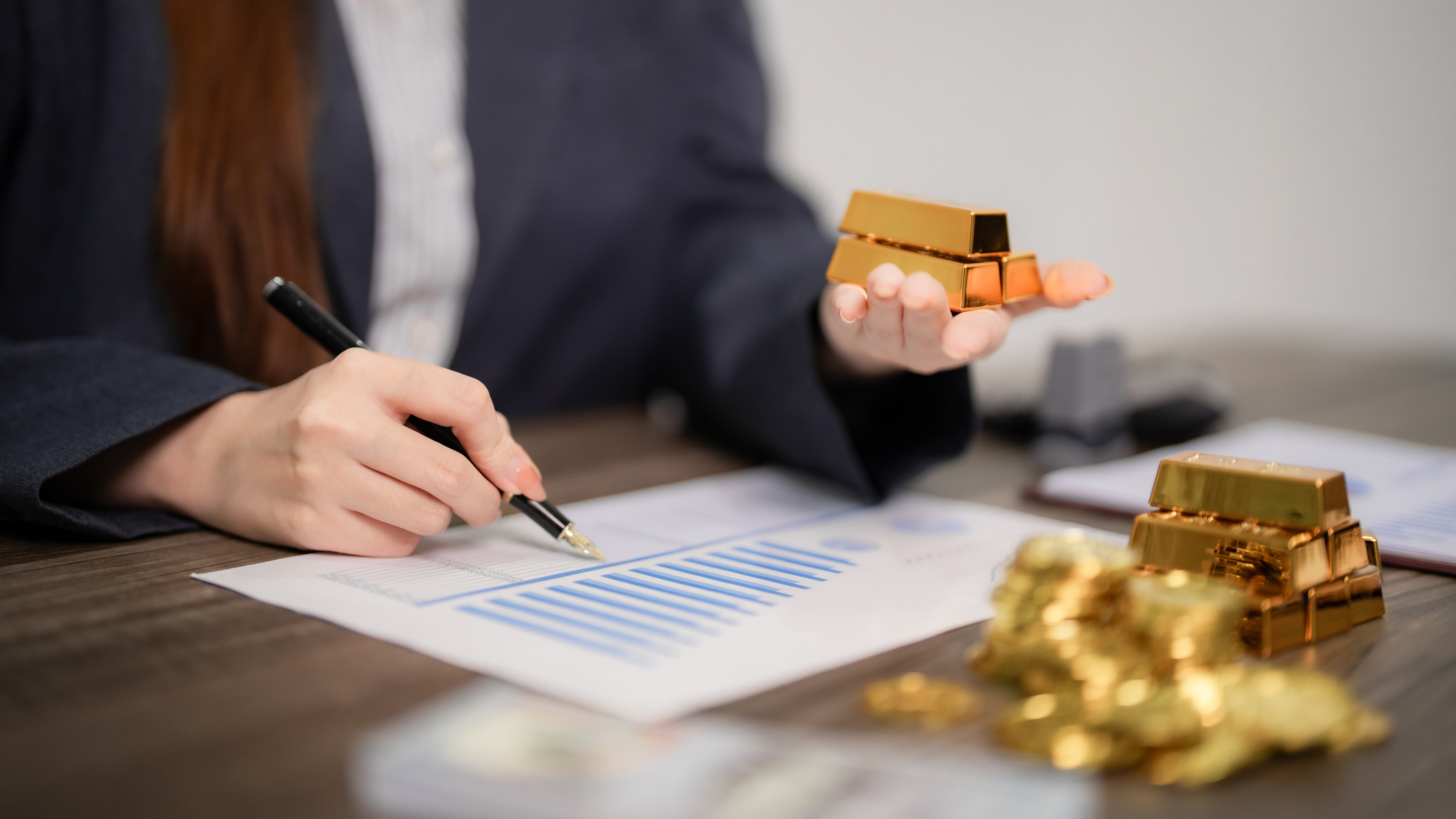Financial professionals reviewing physical gold and market data